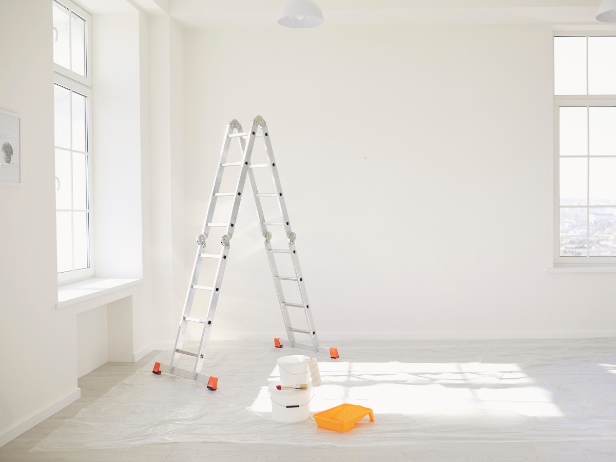 An empty room with work tools, undergoing renovations