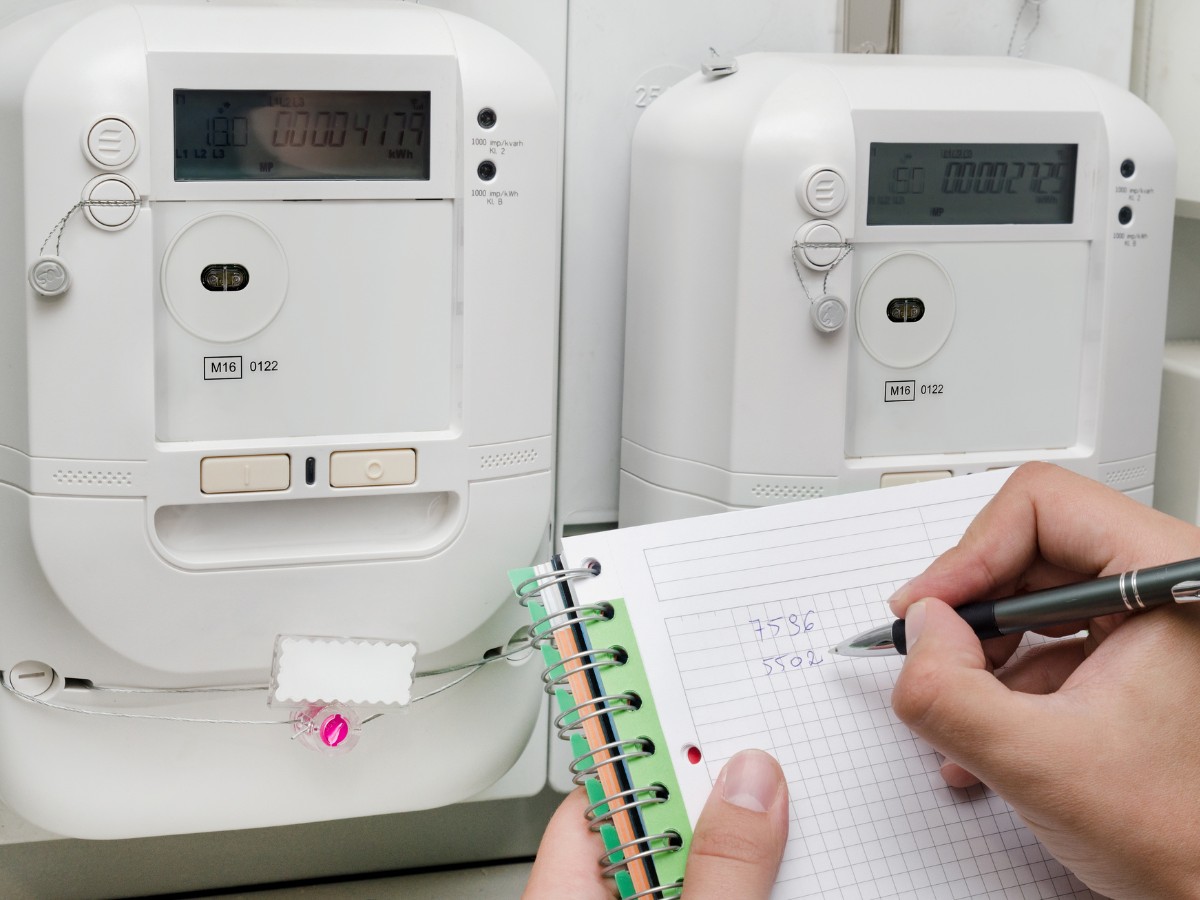 A gas or electric meter reading being noted by a service technician